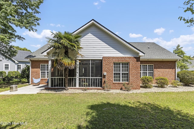 3733 Winstead Cir, Southport, NC 28461 - back of house with a sunroom, brick siding, a yard, a patio, and a shingled roof