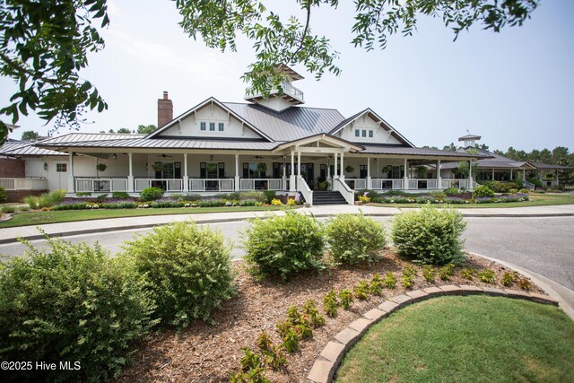 3733 Winstead Cir, Southport, NC 28461 - view of front facade featuring covered porch, a chimney, a standing seam roof, a ceiling fan, and metal roof