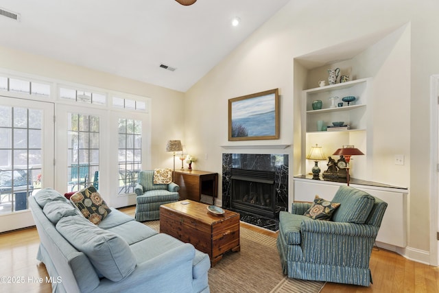 3733 Winstead Cir, Southport, NC 28461 - living room featuring visible vents, a wealth of natural light, a premium fireplace, and light wood-type flooring