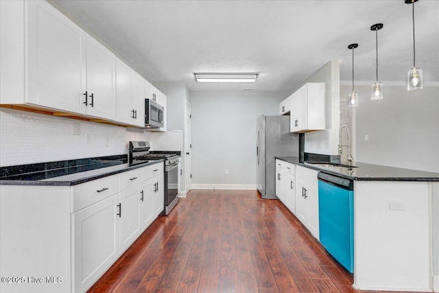 kitchen with white cabinets, a sink, appliances with stainless steel finishes, dark wood finished floors, and backsplash