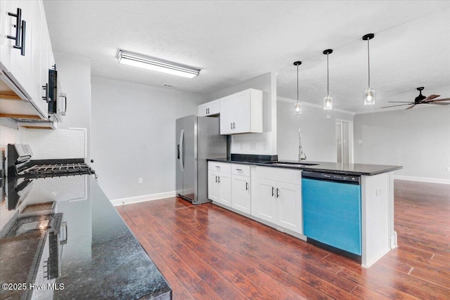 kitchen with dark wood-style floors, a sink, stainless steel appliances, ceiling fan, and backsplash