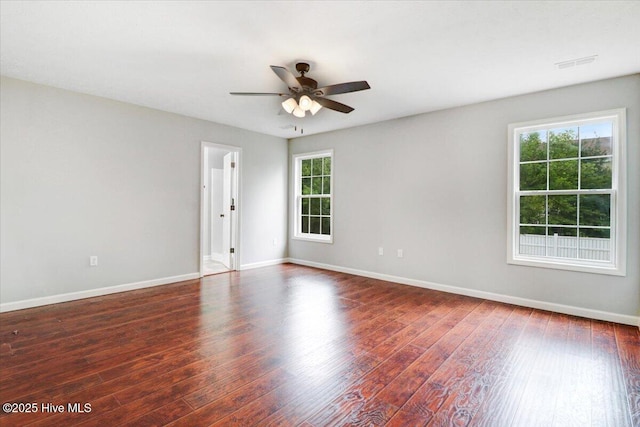 empty room featuring baseboards, wood finished floors, a healthy amount of sunlight, and ceiling fan