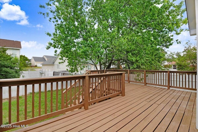 wooden terrace with a yard and a fenced backyard
