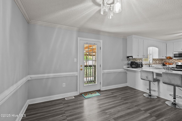 5065 Chris Rd, Bailey, NC 27807 - kitchen featuring appliances with stainless steel finishes, light countertops, arched walkways, a textured ceiling, and ornamental molding