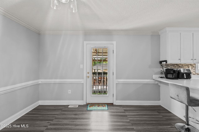 5065 Chris Rd, Bailey, NC 27807 - unfurnished dining area featuring baseboards, ornamental molding, a textured ceiling, and dark wood-type flooring