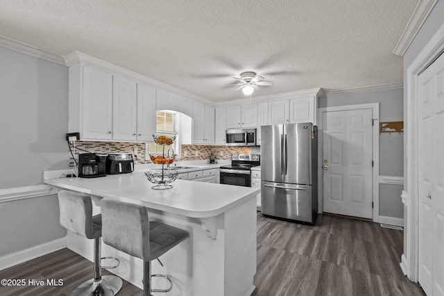 5065 Chris Rd, Bailey, NC 27807 - kitchen featuring white cabinets, stainless steel appliances, a peninsula, and dark wood-style floors