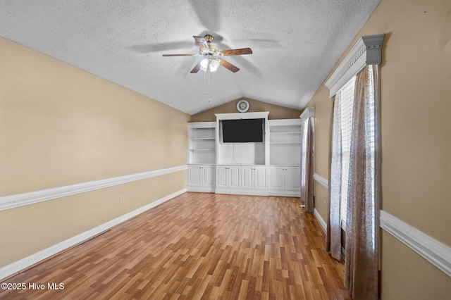 5065 Chris Rd, Bailey, NC 27807 - unfurnished living room featuring a ceiling fan, a textured ceiling, vaulted ceiling, baseboards, and light wood-style floors