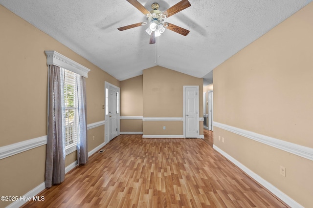 5065 Chris Rd, Bailey, NC 27807 - spare room featuring light wood-style floors, a textured ceiling, a ceiling fan, baseboards, and lofted ceiling