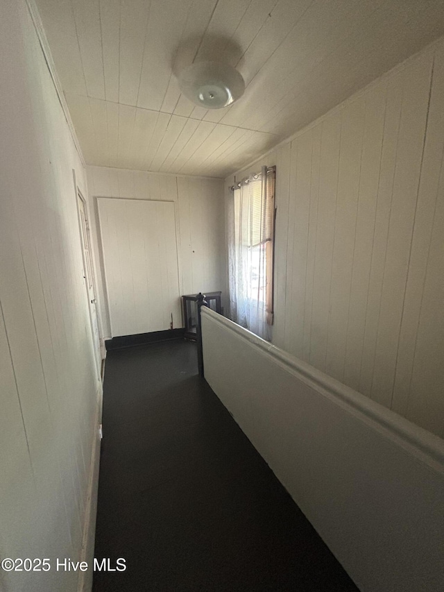 hallway featuring wood walls