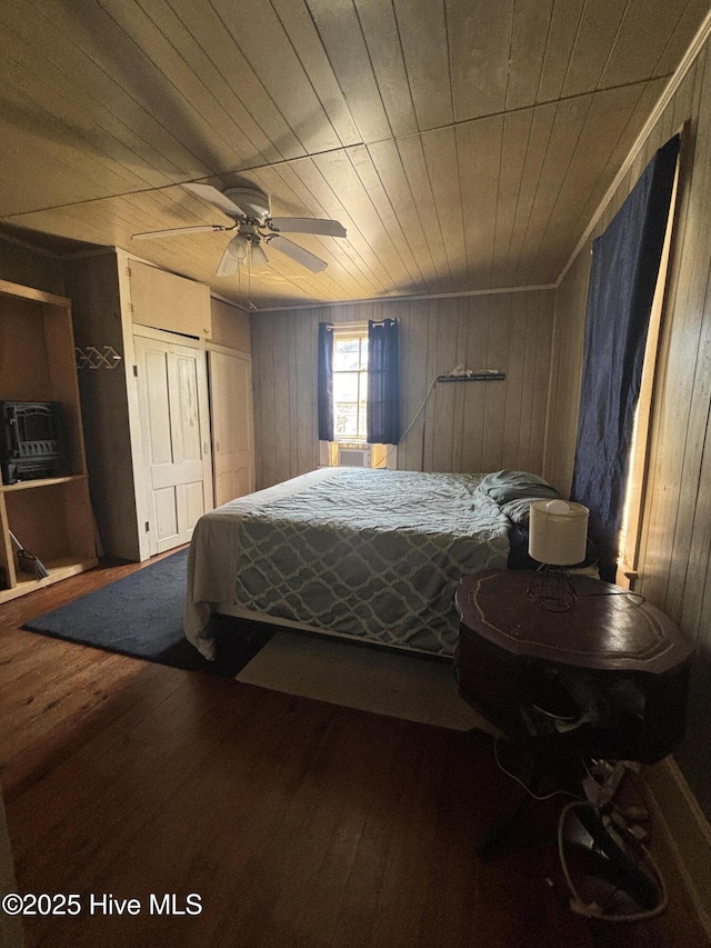 bedroom featuring wooden ceiling, ceiling fan, wood walls, and wood finished floors