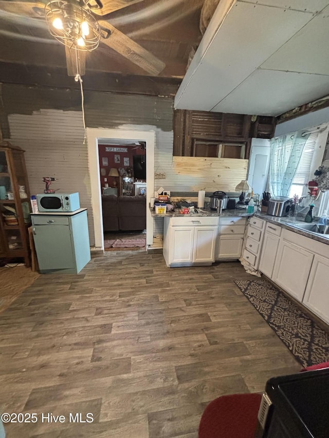 kitchen with dark wood-style flooring, a sink, white cabinetry, a ceiling fan, and white microwave