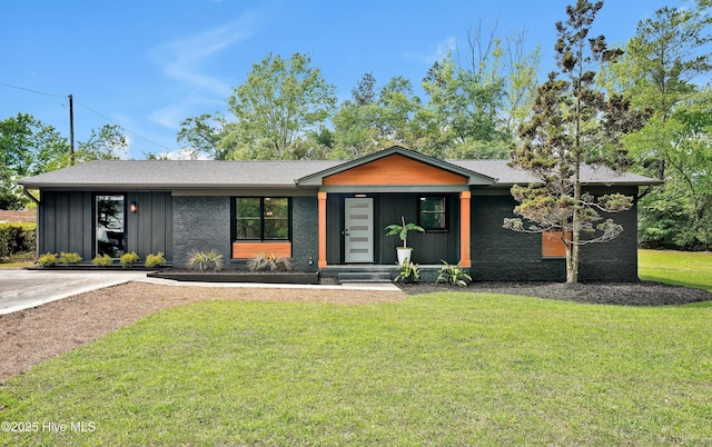 mid-century inspired home with brick siding, a front lawn, and board and batten siding