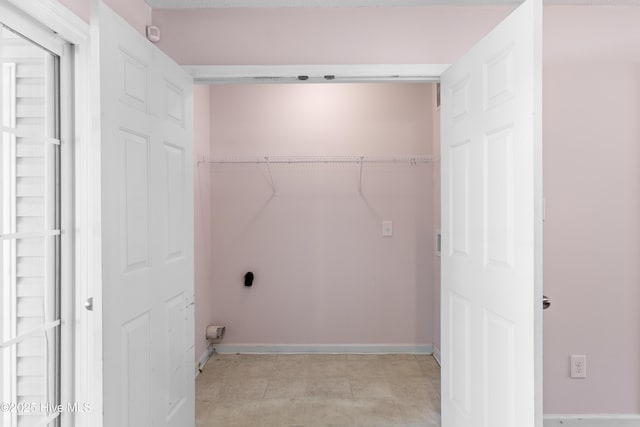 laundry area with hookup for an electric dryer, laundry area, and baseboards