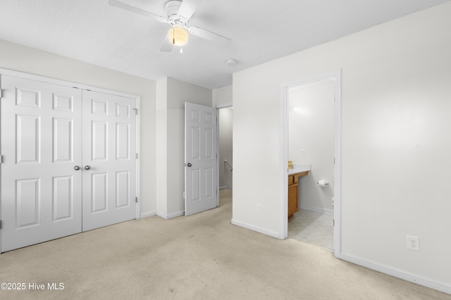 unfurnished bedroom featuring carpet floors, a closet, baseboards, a ceiling fan, and ensuite bath