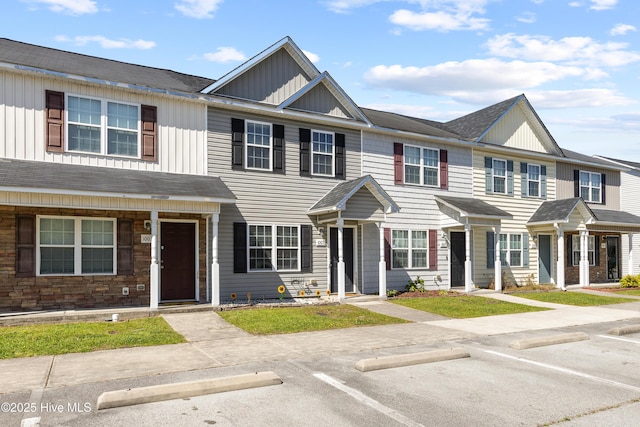 multi unit property featuring board and batten siding and uncovered parking