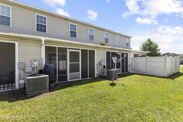 back of property with a yard, central AC, and fence