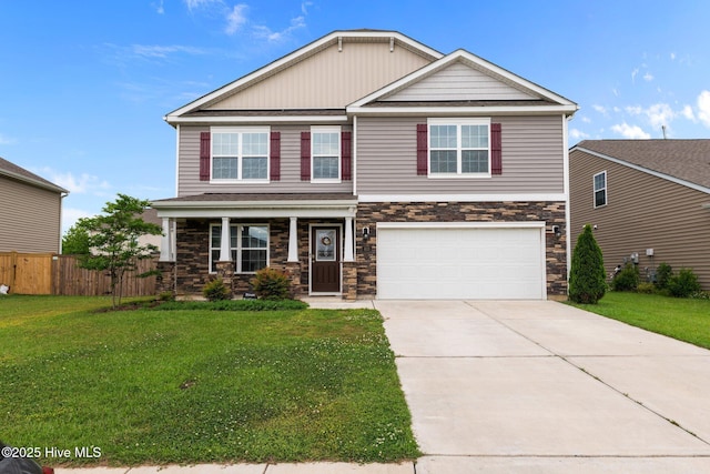 craftsman-style house featuring a garage, fence, a front yard, stone siding, and driveway
