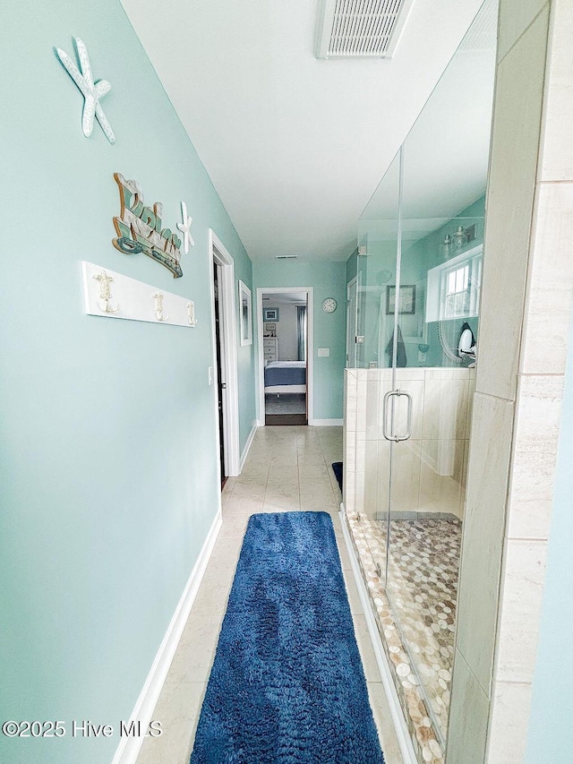 corridor with visible vents, baseboards, and tile patterned floors