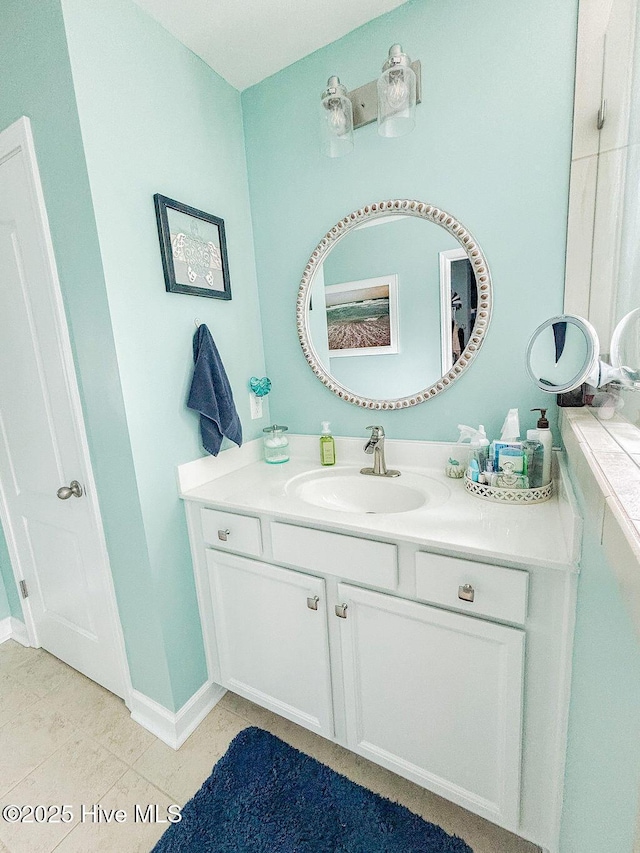 full bathroom featuring vanity, tile patterned flooring, and baseboards