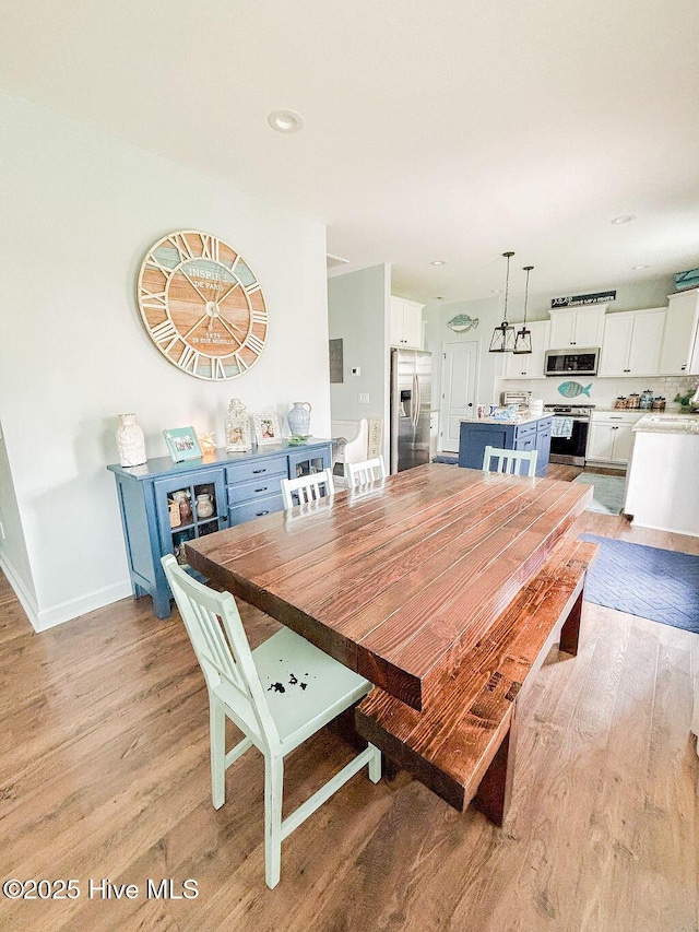 dining room with baseboards and light wood finished floors