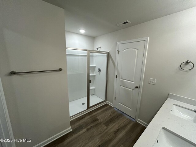 586 Chicod St, Grimesland, NC 27837 - full bathroom with double vanity, a shower stall, wood finished floors, and visible vents