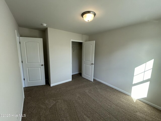 586 Chicod St, Grimesland, NC 27837 - unfurnished bedroom with baseboards, a closet, and dark carpet