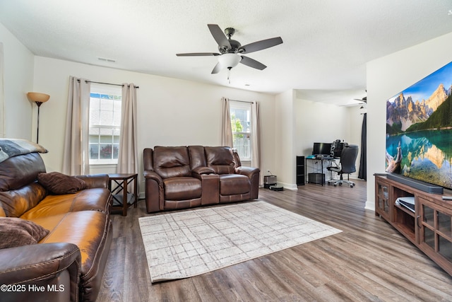 living area with ceiling fan, visible vents, a healthy amount of sunlight, and wood finished floors