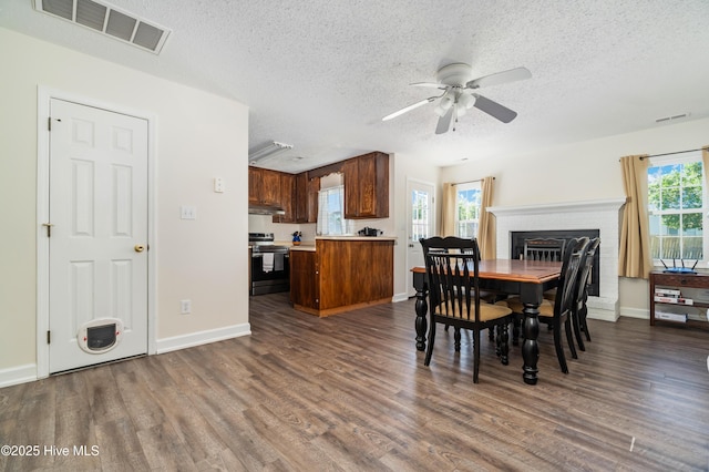 dining area with visible vents, dark wood-type flooring, a textured ceiling, and ceiling fan