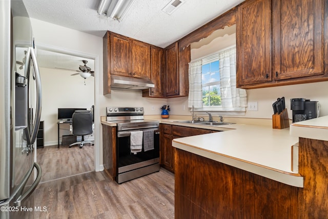 kitchen with visible vents, under cabinet range hood, a sink, dark wood finished floors, and appliances with stainless steel finishes