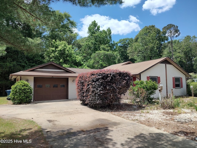 ranch-style house featuring concrete driveway and a garage