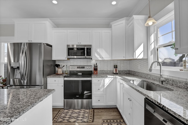 kitchen featuring a sink, white cabinets, crown molding, dark wood-style flooring, and appliances with stainless steel finishes
