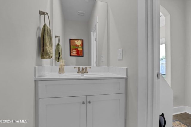 bathroom featuring vanity, baseboards, and wood finished floors