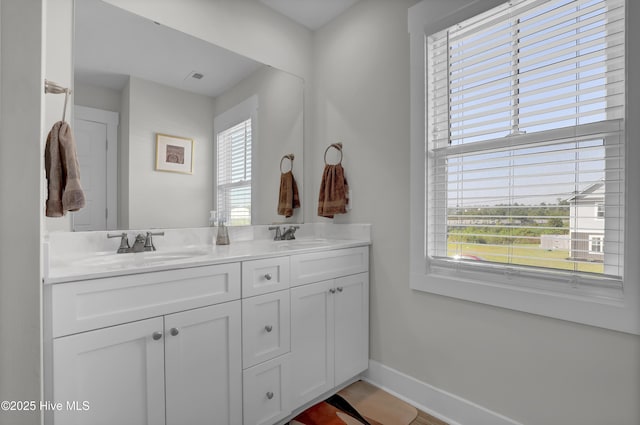 full bathroom featuring plenty of natural light, baseboards, and a sink
