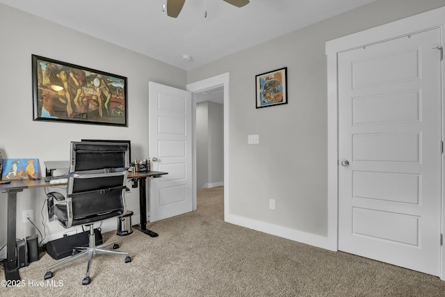 carpeted office space with baseboards and ceiling fan