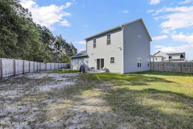 back of house with a yard and a fenced backyard