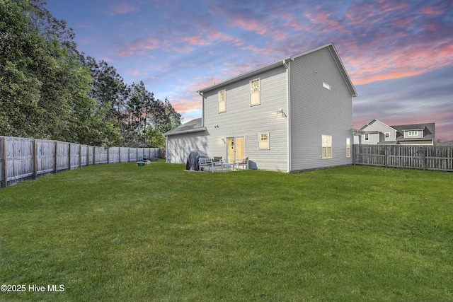back of property featuring a yard and a fenced backyard