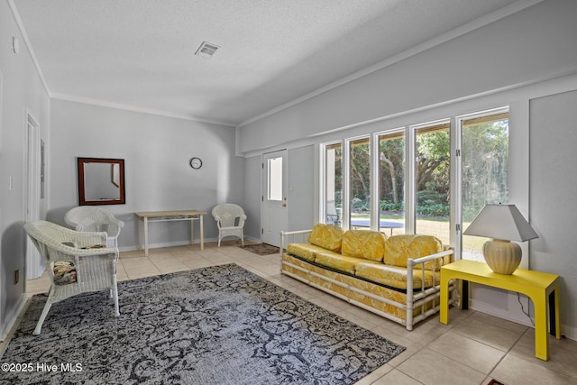 living area featuring ornamental molding, a textured ceiling, tile patterned floors, and a healthy amount of sunlight