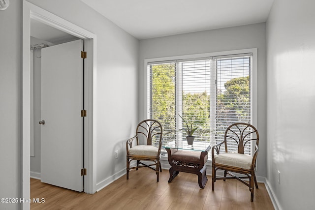 sitting room featuring baseboards and light wood-style floors