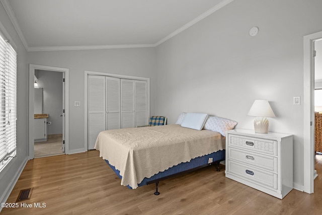 bedroom with light wood-type flooring, ornamental molding, lofted ceiling, and a closet