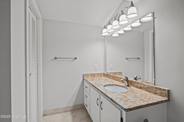 bathroom featuring vanity, baseboards, a closet, and tile patterned flooring