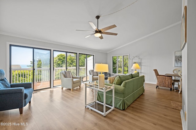 living area featuring crown molding, a ceiling fan, vaulted ceiling, and wood finished floors