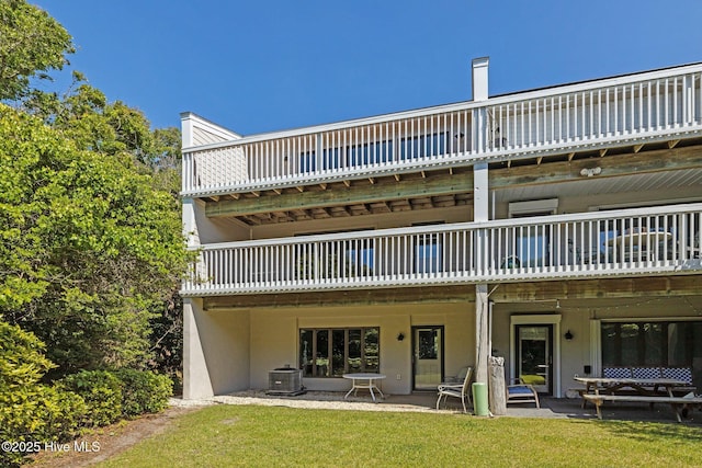rear view of house featuring central air condition unit, a lawn, and a wooden deck