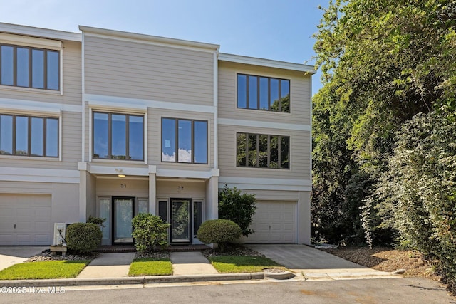 view of property featuring concrete driveway and an attached garage