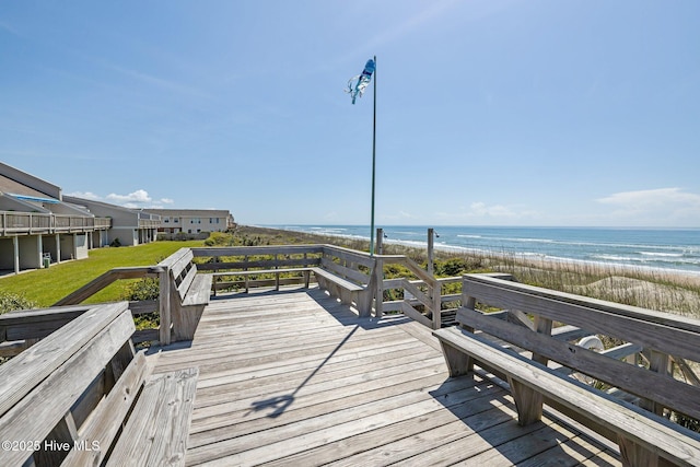 deck with a beach view, a water view, and a yard