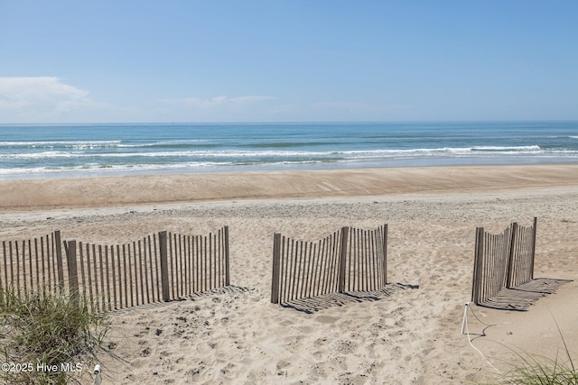 water view with a beach view and fence