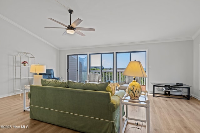 living room featuring a ceiling fan, baseboards, wood finished floors, lofted ceiling, and ornamental molding