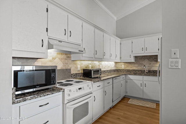 kitchen with crown molding, a sink, under cabinet range hood, white appliances, and white cabinetry