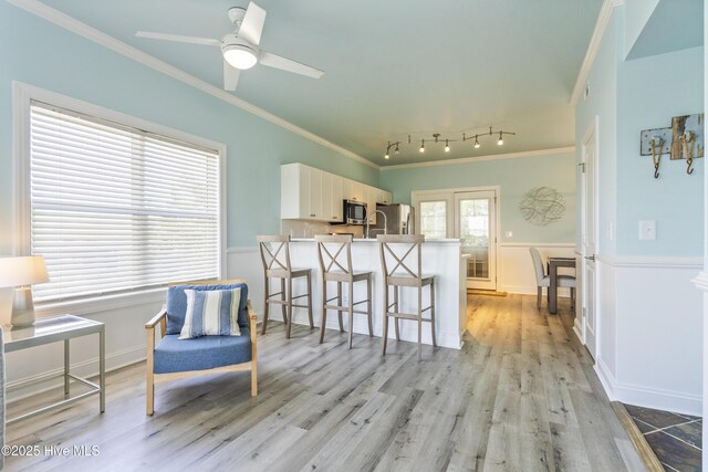 615 N New River Dr Unit E, Surf City, NC 28445 - kitchen with a breakfast bar area, crown molding, a peninsula, light wood finished floors, and stainless steel appliances