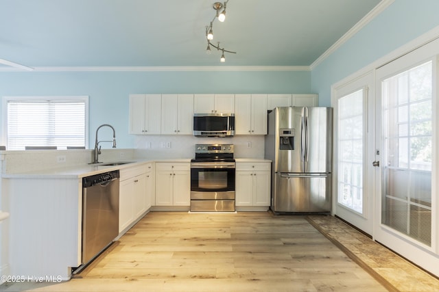615 N New River Dr Unit E, Surf City, NC 28445 - kitchen with appliances with stainless steel finishes, a sink, light countertops, light wood-style flooring, and ornamental molding