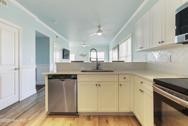 615 N New River Dr Unit E, Surf City, NC 28445 - kitchen featuring a peninsula, a ceiling fan, a sink, stainless steel appliances, and ornamental molding